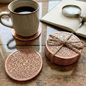 handcrafted metal coasters, antique copper finish coasters, floral embossed table decor, luxury housewarming gift India, drip proof metal drink coasters, premium office desk accessories, artisanal coffee table accents, festive home decoration items, vintage style metal coasters, eco friendly gift packaging decor.